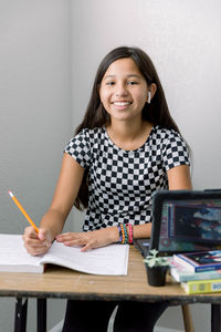 Portrait of smiling girl writing in book at home