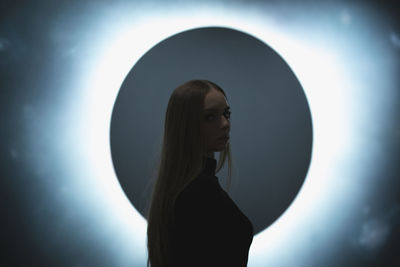 Portrait of woman standing against wall