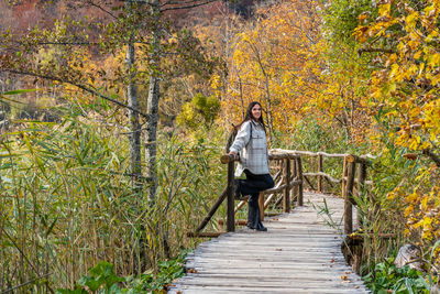 Girl on wooden footpath in plitvice lakes national park in croatia in autumn