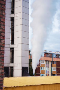 Smoke emitting from chimney against sky