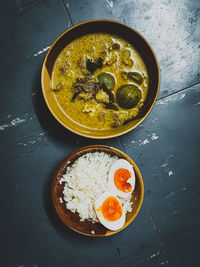 High angle view of green curry breakfast served on table