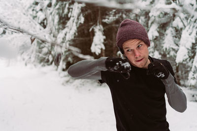 Man jumping by snowy tree