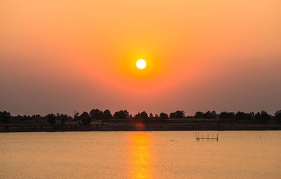 Scenic view of lake against orange sky