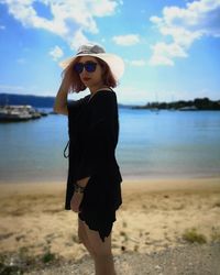 Full length of young woman standing on beach