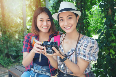 Portrait of smiling young women holding camera