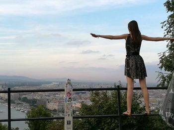 Rear view of woman standing against sky