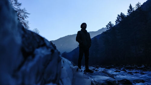 Man standing on snow covered land against sky