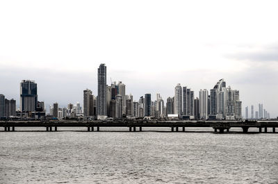 City at waterfront against clear sky