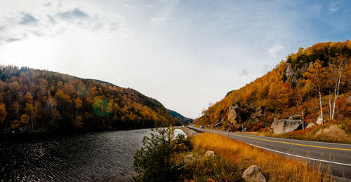 Scenic view of river amidst mountains against sky