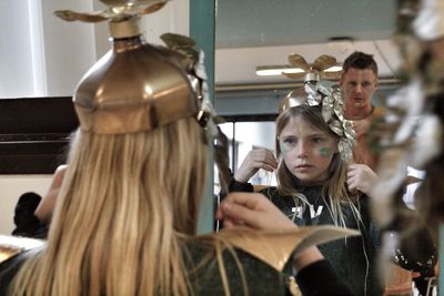 Portrait of woman with reflection of people in mirror