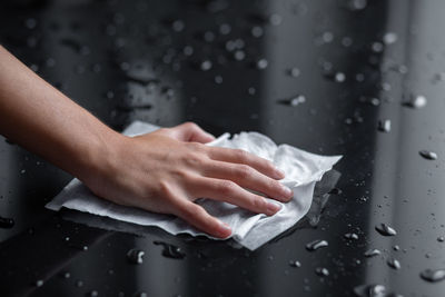 Close-up of woman hand holding wet paper