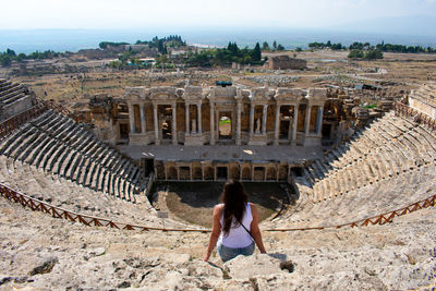 Rear view of woman sitting in amphitheater
