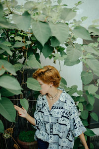 Young woman looking away while amidst the plants