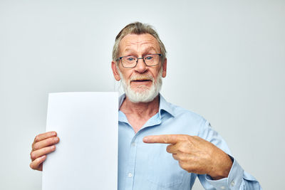 Portrait of senior man showing against white background