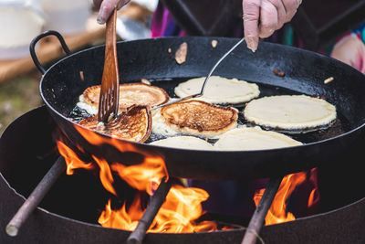 Cooking blini, blin or blynai, pancakes traditional sweet food, preparing outdoor on an open fire