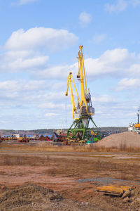 Harbor crane against the blue sky and ships