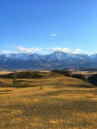 Scenic view of field and altay mountains against sky