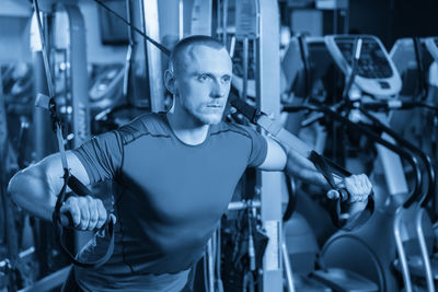 Portrait of young man exercising in gym