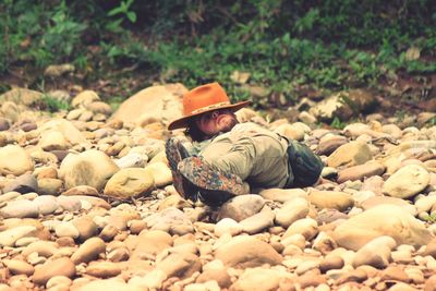 Full length of man sleeping on rocks