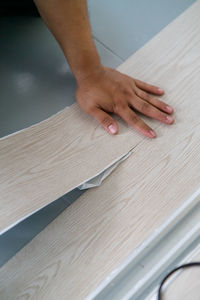 A person installing new vinyl tile floor, a diy home project.