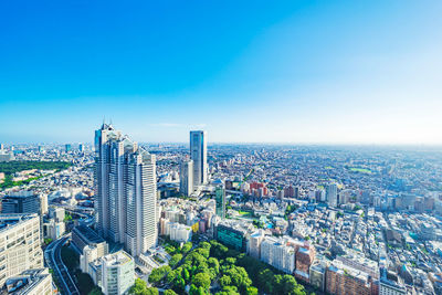 High angle view of city buildings against blue sky