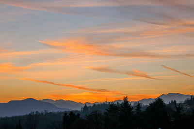 Scenic view of silhouette mountains against orange sky