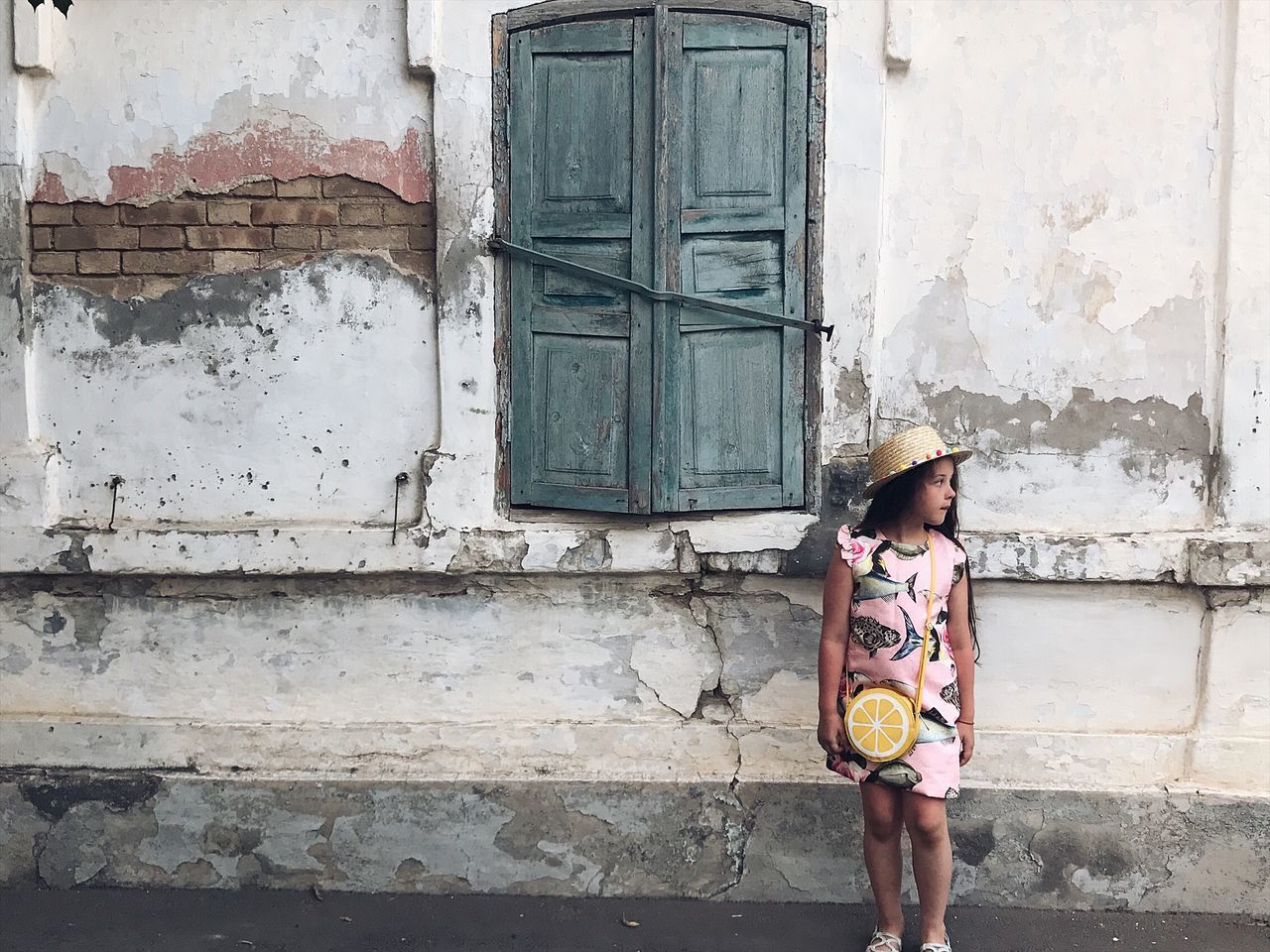 FULL LENGTH OF WOMAN STANDING ON BUILDING WALL