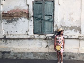 Full length of woman standing against building