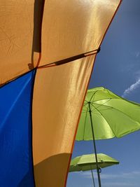 Low angle view of parasol against blue sky