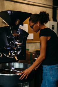 Side view of young woman working in cafe
