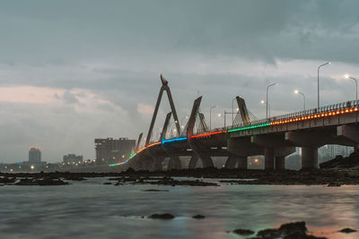 Bridge over river against sky during sunset