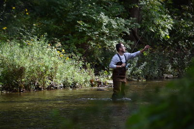 Man standing by lake in forest