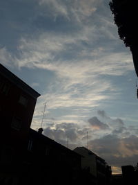 Low angle view of silhouette buildings against sky