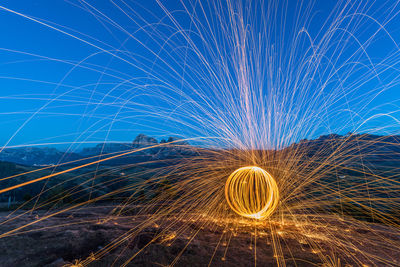 Light trails on illuminated sky at night