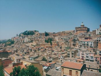 Buildings in town against clear blue sky