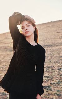 Young woman looking away while standing on land