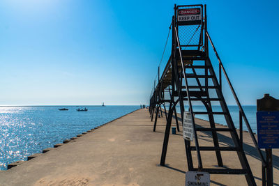 Pier over sea against blue sky