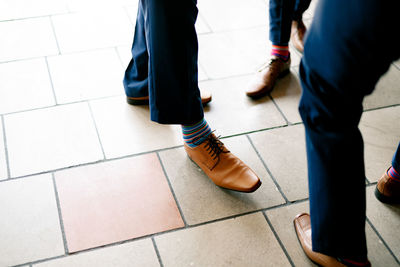 Low section of people standing on tiled floor