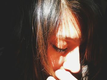 Sunlight falling on woman in darkroom