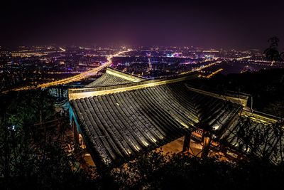 Illuminated cityscape against sky at night