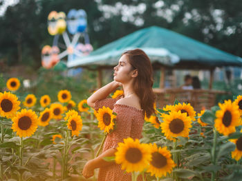 Full length of woman standing on sunflower