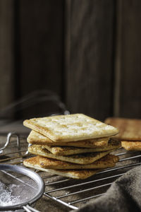 Square dry crackers biscuit on a wooden table. wooden texture dark background. snack dry biscuits 