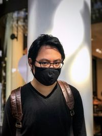 Portrait of young man standing inside mall