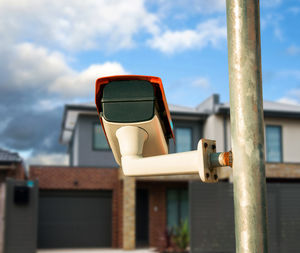 Low angle view of camera on railing against sky