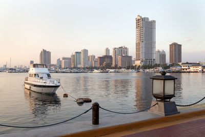 Sea and modern buildings in city against sky