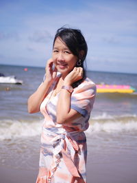 Portrait of young woman sitting at sea