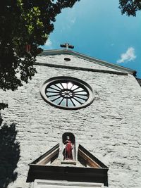 Low angle view of cross on tree against sky