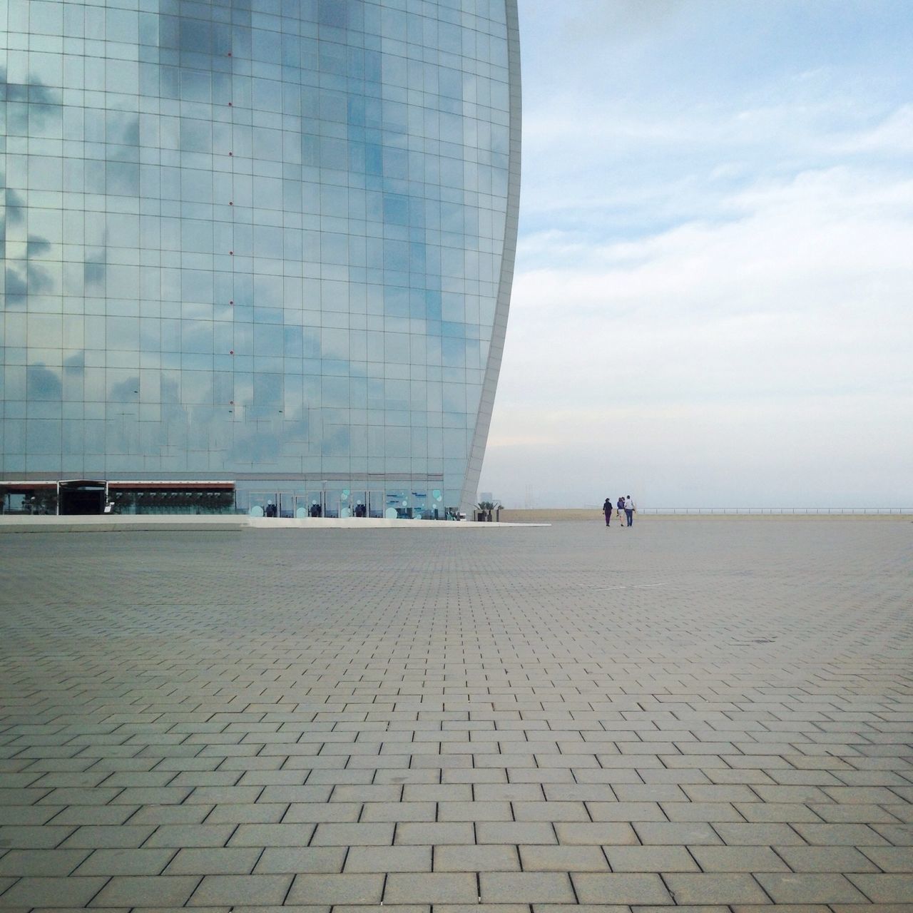 sky, built structure, architecture, sea, building exterior, water, beach, cloud - sky, day, incidental people, men, city, transportation, horizon over water, outdoors, travel, cloud, sand, modern