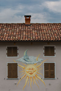 Exterior of house with mural painting against sky
