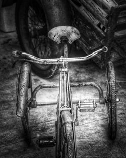 Close-up of abandoned bicycle against wall